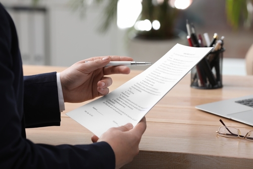 Man,Reading,Document,At,Table,In,Office,,Closeup.,Signing,Contract