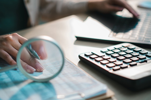 Financial,Documents,With,Calculator,,Pen,And,Magnifying,Glass,On,Desk,