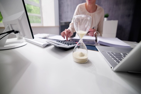 Late,Invoice,And,Billing,Deadline,With,Hourglass,At,Desk