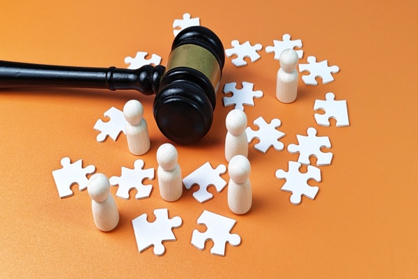 Judge,Gavel,With,Wooden,Dolls,And,White,Puzzle,Pieces,On