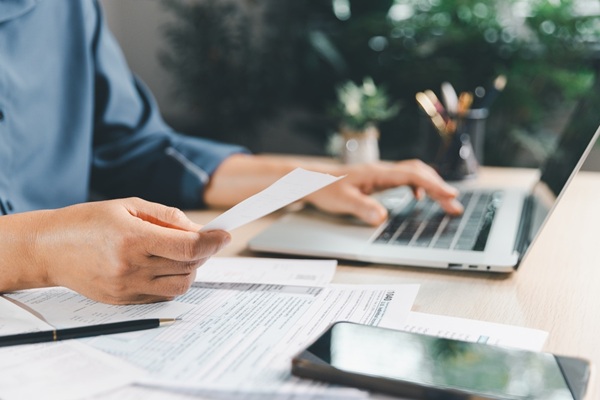 Tax,Preparation,At,Office,Desk,With,Hands,Holding,Receipt,And