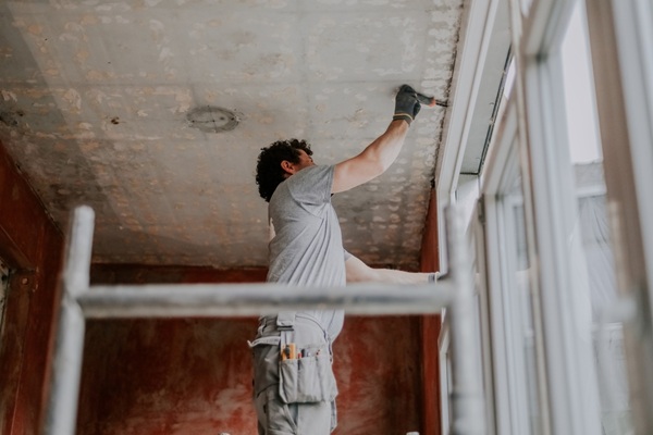 One,Young,Caucasian,Man,Stands,Sideways,On,Scaffolding,And,Uses