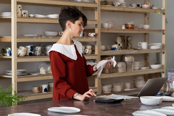 Young,Busy,Focused,Woman,Entrepreneur,Doing,Paperwork,,Female,Artisan,Ceramics