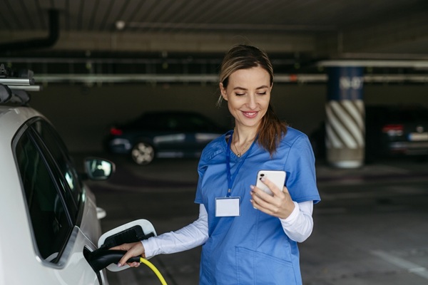 Nurse,Plugging,Charger,Into,Electric,Car,Before,Going,To,Work.