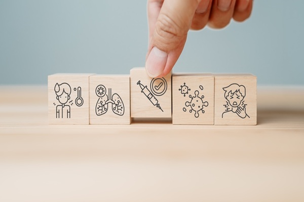 Close,Up,Of,Hand,Placing,Wooden,Block,With,Syringe,And